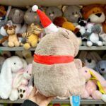 М'яка іграшка з червоною стрічкою і шапкою