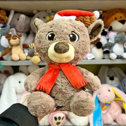 М'який олень в червоній шапці та шарфі