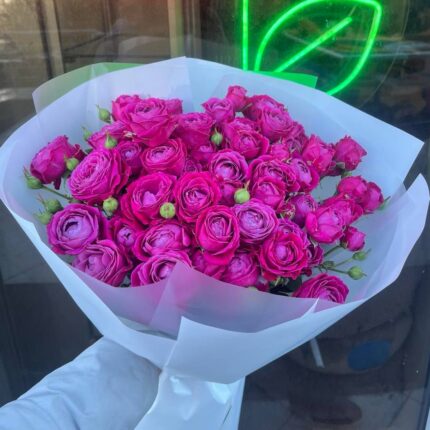 Букет яскравих рожевих троянд у руці.