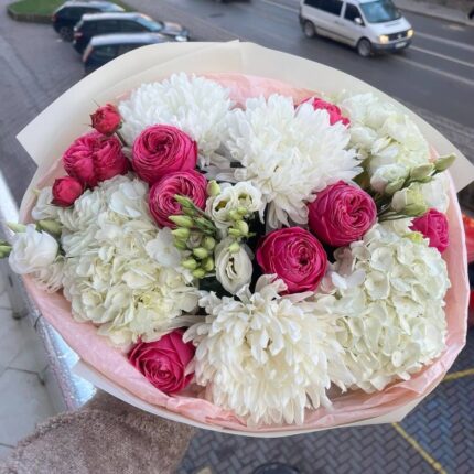 Букет з різнокольорових квітів у руках.