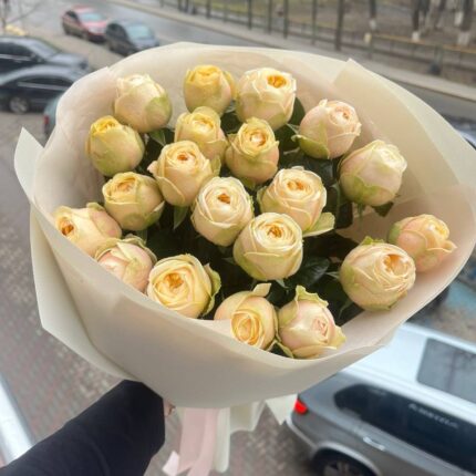 Букет світлих троянд на фоні вулиці