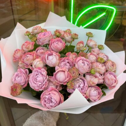 Букет рожевих троянд на фоні неонового малюнка