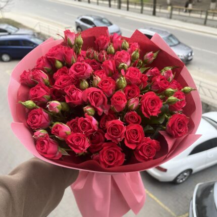 Букет яскравих червоних троянд у руках