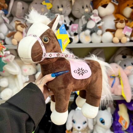 М’яка іграшка коня на фоні інших іграшок