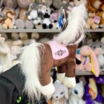 Плюшевий кінь з білою гривою та сідлом