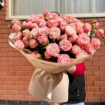 Величезний букет рожевих троянд на вулиці