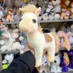 М'яка іграшка коня в руках.