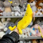 Плюшева бананова іграшка на фоні інших ведмедів