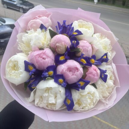 Букет із півоній та ірисів на фоні вулиці