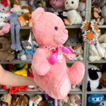 Рожевий ведмедик з бантом на шиї